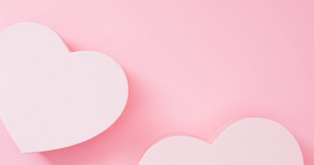 Two white hearts on a soft pink background, conveying love and romance (decorative image)