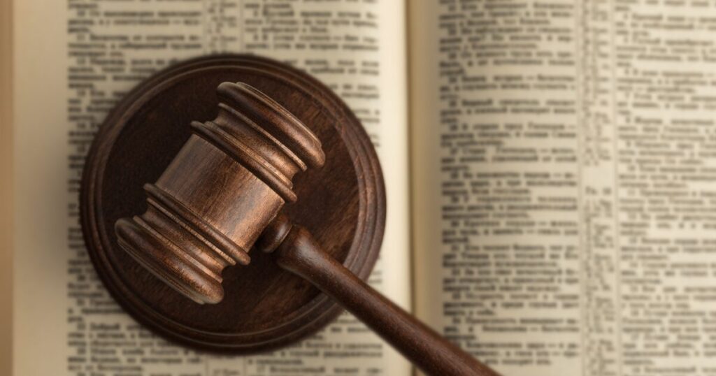 Wooden judge's gavel resting on an open book, symbolizing legal decision or courtroom authority.